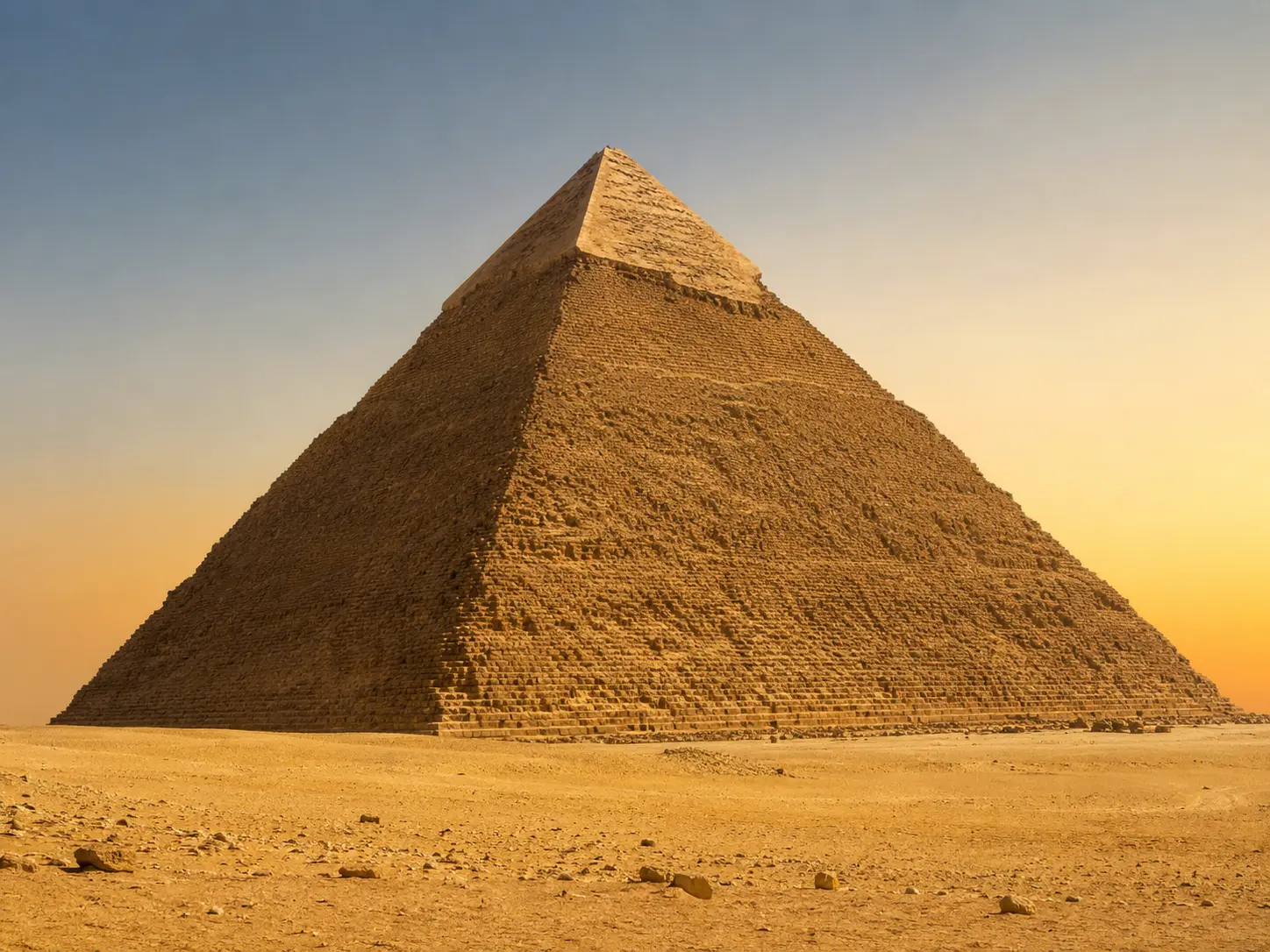 Seitenansicht der Cheops-Pyramide in Gizeh unter klarem Himmel mit weitläufiger Wüstenlandschaft