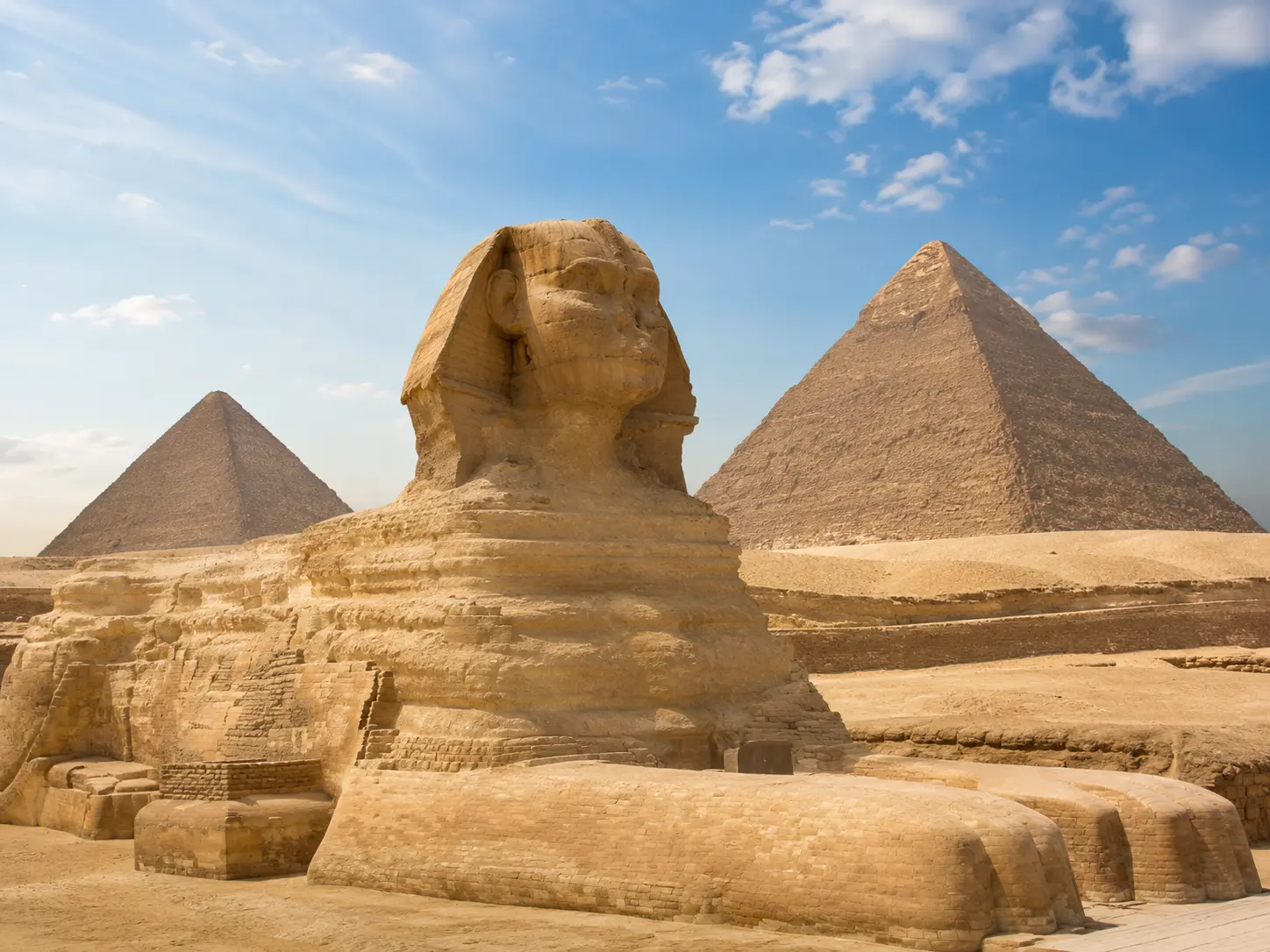 Große Sphinx von Gizeh mit den Pyramiden im Hintergrund bei warmem Sonnenlicht